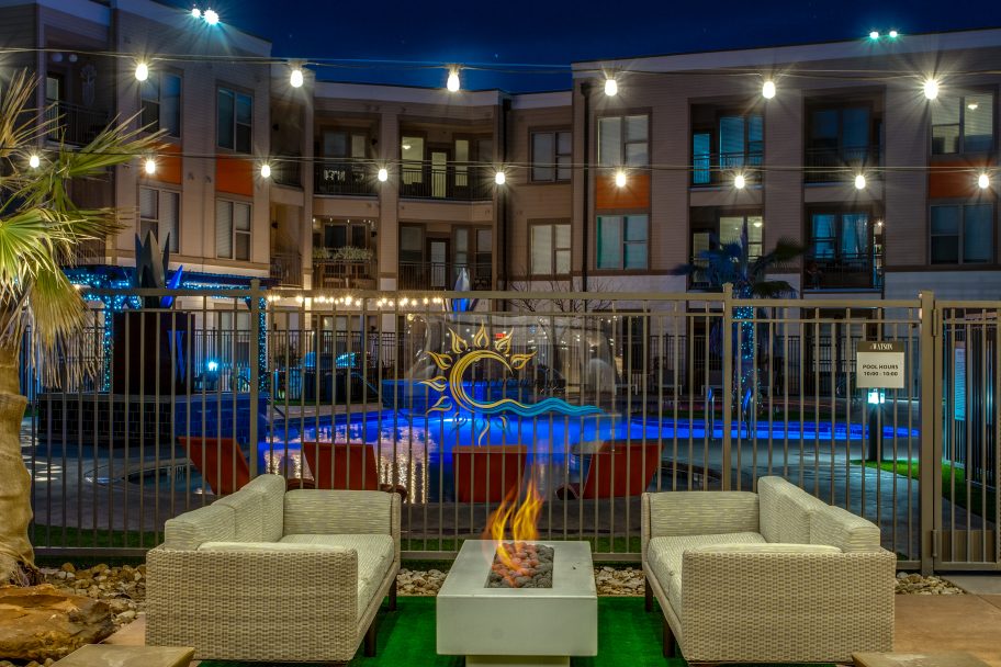 the patio area at night with fire pits and lounge chairs at The  Watson