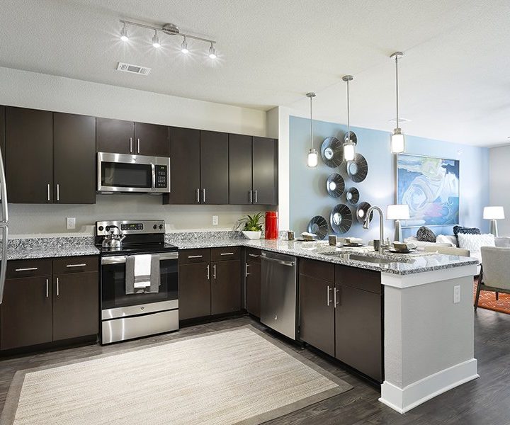 a kitchen with stainless steel appliances and wood floors at The  Watson