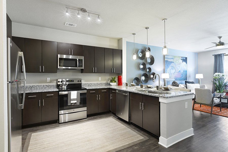 a kitchen with stainless steel appliances and wood floors at The  Watson